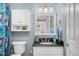 Updated bathroom with black countertop vanity, storage, and decorative mirror at 402 Hearthstone Dr, Nashville, NC 27856