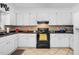 Functional kitchen with white cabinets, tile backsplash, and modern appliances at 402 Hearthstone Dr, Nashville, NC 27856