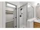 Modern bathroom featuring a glass-enclosed shower, tiled walls, and an adjacent walk-in closet at 4211 Norman Ridge Ln, Raleigh, NC 27613