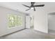 Cozy bedroom with natural light, ceiling fan, carpeted floors, and an en-suite bathroom at 4211 Norman Ridge Ln, Raleigh, NC 27613