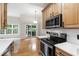 Kitchen featuring light wood cabinets, stainless steel appliances, and access to dining area at 4211 Norman Ridge Ln, Raleigh, NC 27613