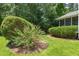 Landscaped backyard showcasing manicured bushes, flowers, and a screened-in porch at 4613 Moores Creek Rd, Durham, NC 27705