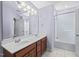 Bright bathroom featuring a double sink vanity, large mirror, and combined tub and shower at 4613 Moores Creek Rd, Durham, NC 27705