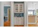 The butler's pantry features white cabinets, glass doors, and is nestled between stately columns at 4613 Moores Creek Rd, Durham, NC 27705