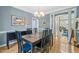 Open dining room with an elegant light fixture and hardwood floors that flows into the living space at 4613 Moores Creek Rd, Durham, NC 27705