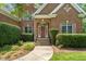 Charming brick home featuring a welcoming front entrance with a manicured lawn and mature landscaping at 4613 Moores Creek Rd, Durham, NC 27705