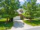 Traditional brick home featuring a two-car garage, driveway, and manicured lawn at 4613 Moores Creek Rd, Durham, NC 27705
