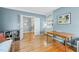 This office features blue walls, hardwood floors, built-in shelving, and a bright, airy feel with open doorway at 4613 Moores Creek Rd, Durham, NC 27705