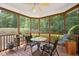 This screened in porch has a ceiling fan, a wood deck, and views of the wooded backyard at 4613 Moores Creek Rd, Durham, NC 27705
