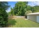 Fenced backyard featuring a green lawn, a fire pit, and mature trees at 502 S Eighth St, Mebane, NC 27302