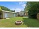 Spacious backyard with a brick fire pit, well-maintained lawn, and detached garage at 502 S Eighth St, Mebane, NC 27302