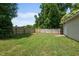 Fenced backyard featuring a green lawn, a fire pit, and mature trees at 502 S Eighth St, Mebane, NC 27302