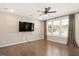 Relaxing living room with hardwood floors, a ceiling fan, large window and a wall-mounted TV at 513 Brooks St, Wake Forest, NC 27587
