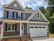 Charming two-story home with gray siding, black shutters, and a spacious white two-car garage at 5905 Genesee Dr., Homesite 6, Durham, NC 27712