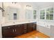 Bright bathroom with double sinks, dark cabinets, and a separate tub and shower at 613 Penncross Dr, Raleigh, NC 27610