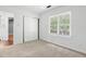 Bright bedroom features a double door closet, window and neutral carpet at 613 Penncross Dr, Raleigh, NC 27610