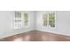 A bedroom featuring hardwood floors, white walls, and bright windows at 613 Penncross Dr, Raleigh, NC 27610