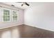 Bedroom featuring wood floors, a ceiling fan, and two windows at 613 Penncross Dr, Raleigh, NC 27610