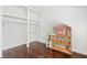 Bright bedroom with wood-look floors, closet with built-in shelving and hanging rod, and a cute dollhouse at 613 Penncross Dr, Raleigh, NC 27610