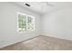 Bright bedroom features a ceiling fan, window and neutral carpet at 613 Penncross Dr, Raleigh, NC 27610