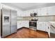 Kitchen features stainless steel appliances, granite countertops, white cabinetry and wood-look floors at 613 Penncross Dr, Raleigh, NC 27610