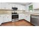 Modern kitchen features stainless steel appliances, granite countertops, and white cabinetry at 613 Penncross Dr, Raleigh, NC 27610