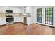 Bright kitchen with stainless appliances, granite counters, white cabinets, and French doors to the backyard at 613 Penncross Dr, Raleigh, NC 27610