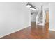 Open concept living area featuring hardwood floors, white walls, and access to the staircase at 613 Penncross Dr, Raleigh, NC 27610