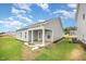 Exterior view of a home with a covered patio, backyard, and gray vinyl siding at 66 W Emily Gardens Dr, Selma, NC 27576