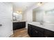 The bathroom features double sinks, a large mirror, white countertops and dark wood cabinets at 66 W Emily Gardens Dr, Selma, NC 27576