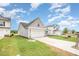 View of a home with vinyl siding, an attached garage and driveway, and green grass at 66 W Emily Gardens Dr, Selma, NC 27576