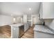 Charming kitchen with stainless steel appliances, grey cabinets and granite countertops, with an open view to the living room at 66 W Emily Gardens Dr, Selma, NC 27576