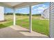 Covered patio looking out at the new construction lot, grass and trees at 66 W Emily Gardens Dr, Selma, NC 27576