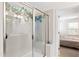 Beautiful shower with decorative tile, glass doors and walls, and hanging plants at 6928 Leesville Rd, Raleigh, NC 27613