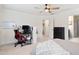 Bright bedroom features neutral carpet, crown molding, ceiling fan, and a workspace with a black desk at 6928 Leesville Rd, Raleigh, NC 27613