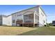 Back exterior of the home with deck and screened-in porch and lush grassy yard at 713 Ramsours Mill Dr, Holly Springs, NC 27540