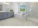 Bathroom featuring a white vanity, large mirror, soaking tub, and tiled shower at 713 Ramsours Mill Dr, Holly Springs, NC 27540