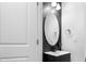 Modern half bath features an oval mirror and black countertop at 713 Ramsours Mill Dr, Holly Springs, NC 27540