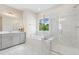 Bright bathroom with double vanity, soaking tub, shower, and large window with natural light at 713 Ramsours Mill Dr, Holly Springs, NC 27540