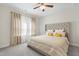 Bright bedroom featuring a ceiling fan, neutral walls, and a stylish, upholstered bed frame with decorative pillows at 713 Ramsours Mill Dr, Holly Springs, NC 27540