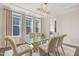 Elegant dining room with a glass-top table, soft chairs, and an elegant chandelier at 713 Ramsours Mill Dr, Holly Springs, NC 27540