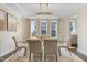Elegant dining room with a glass-top table, plush chairs, and a modern chandelier, perfect for formal gatherings at 713 Ramsours Mill Dr, Holly Springs, NC 27540