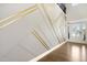 Elegant foyer featuring a custom wall design with gold accents and hardwood floors at 713 Ramsours Mill Dr, Holly Springs, NC 27540