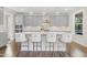 Modern kitchen with island seating, pendant lights and neutral color scheme at 713 Ramsours Mill Dr, Holly Springs, NC 27540