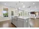 Open concept kitchen with large island, stainless steel sink, pendant lights, and view to living room at 713 Ramsours Mill Dr, Holly Springs, NC 27540
