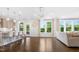 Open concept living room featuring hardwood floors, backyard views, an adjacent kitchen with bar seating at 713 Ramsours Mill Dr, Holly Springs, NC 27540