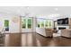 Bright living room boasting hardwood floors, large windows, and a sleek fireplace, offering a modern and airy ambiance at 713 Ramsours Mill Dr, Holly Springs, NC 27540