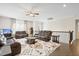 Open-concept living room features hardwood floors, modern ceiling fan, and comfortable leather seating at 713 Ramsours Mill Dr, Holly Springs, NC 27540