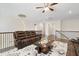 Bright living room with hardwood floors, modern ceiling fan, leather seating and a decorative area rug at 713 Ramsours Mill Dr, Holly Springs, NC 27540