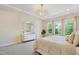 Stylish main bedroom with a decorative gold mirror, plush carpet, and three large windows at 713 Ramsours Mill Dr, Holly Springs, NC 27540